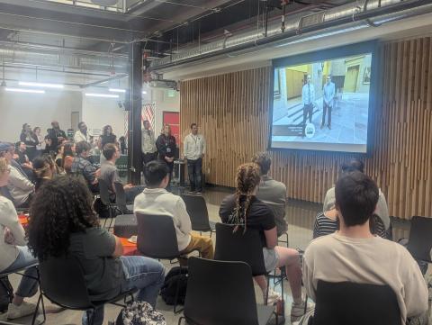 Picture shows pre-recorded remarks from USDA Chief Data & AI Officer Christopher Alvares and NASA Chief Data & AI Officer David Salvagnini kicking off the event. Staff from NASA, USDA, and CSU student-run organization DevNet.CSU watching along with hackathon participants
